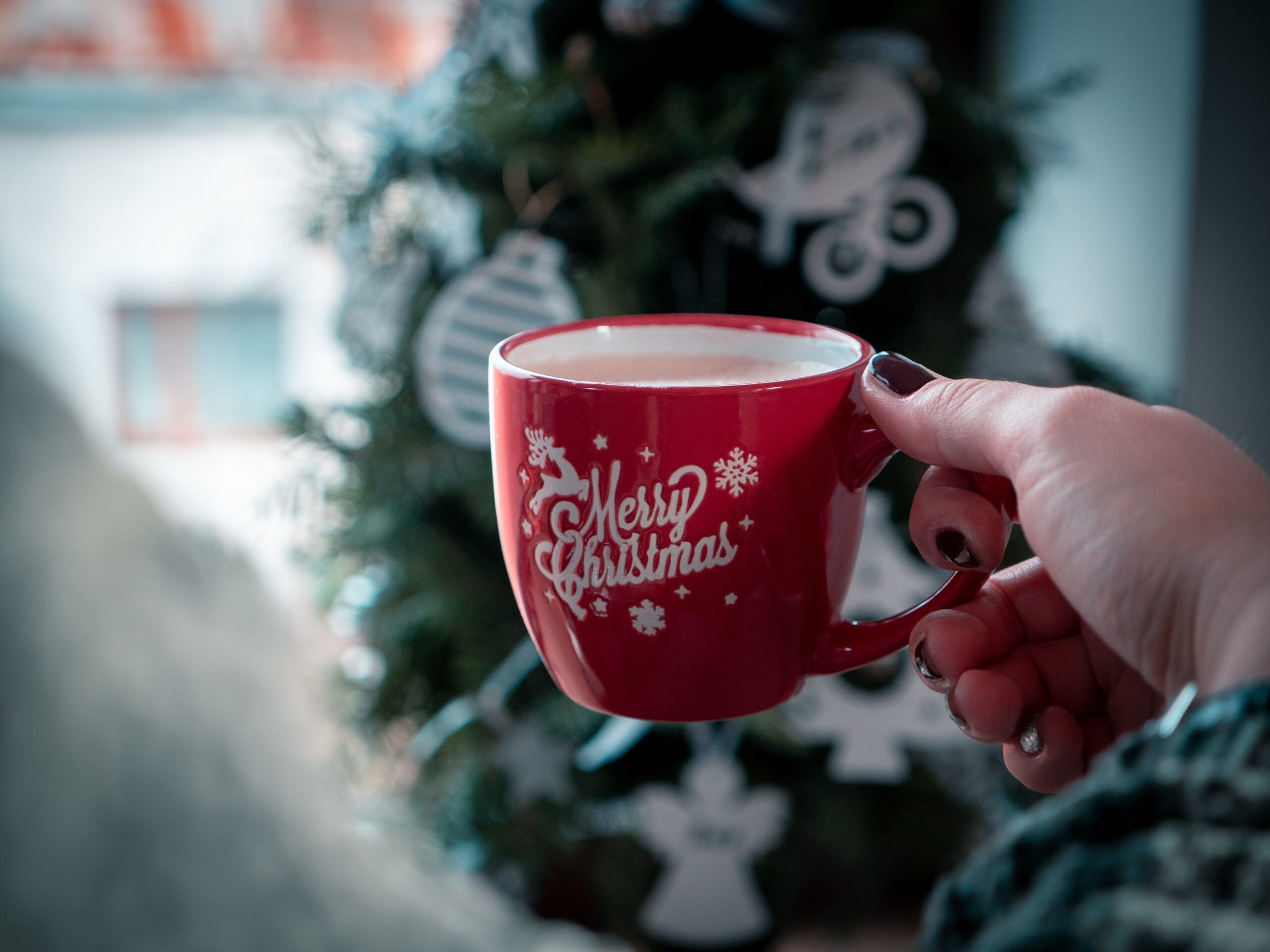 Woman drinking from Merry Christmas mug