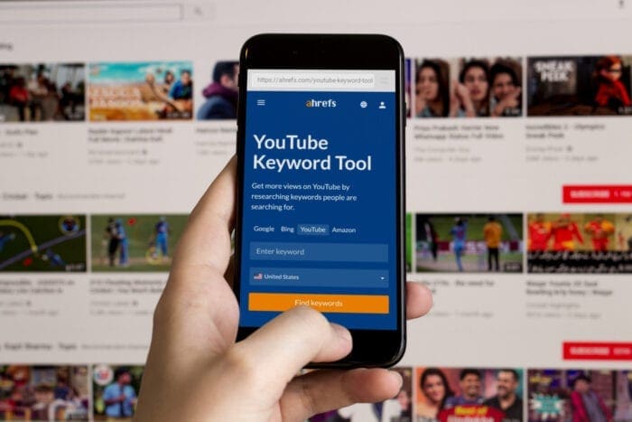 Person browsing Ahrefs YouTube Keyword Tool on iPhone
